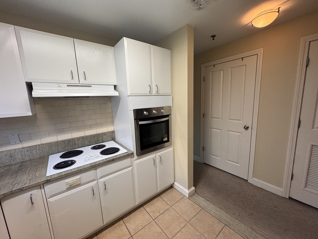 636 Beacon Street, Unit 404 Boston, MA 02215 - Photo 10 of 20 a kitchen with white cabinets and appliances