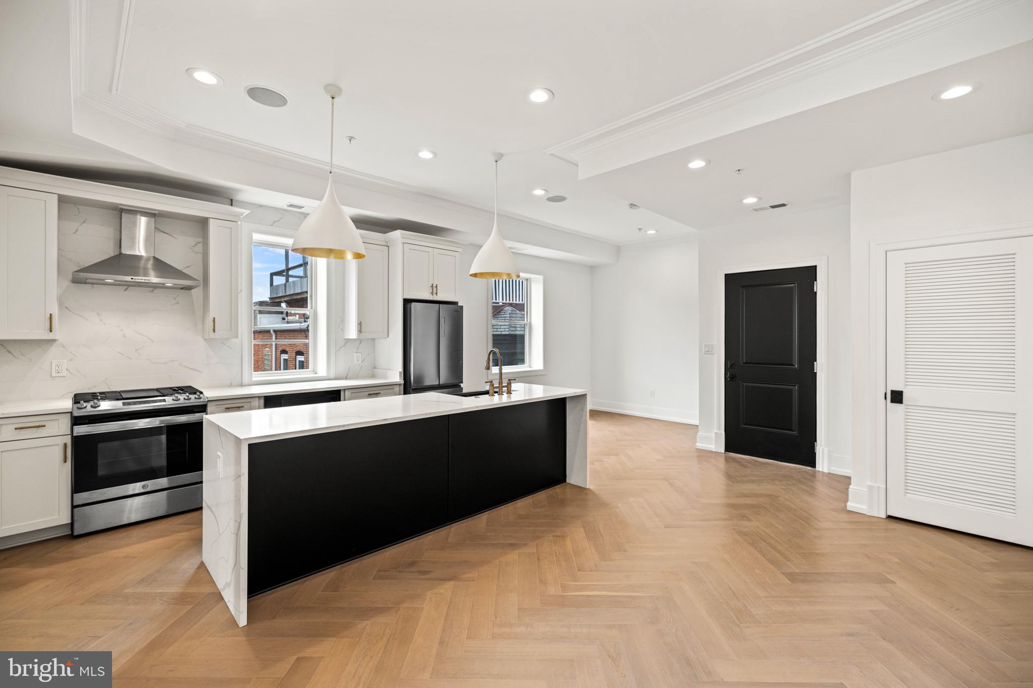 1709 21st Street Northwest, Unit 42 Washington, DC 20009 - Photo 12 of 21 a large kitchen with stainless steel appliances granite countertop a stove and a refrigerator