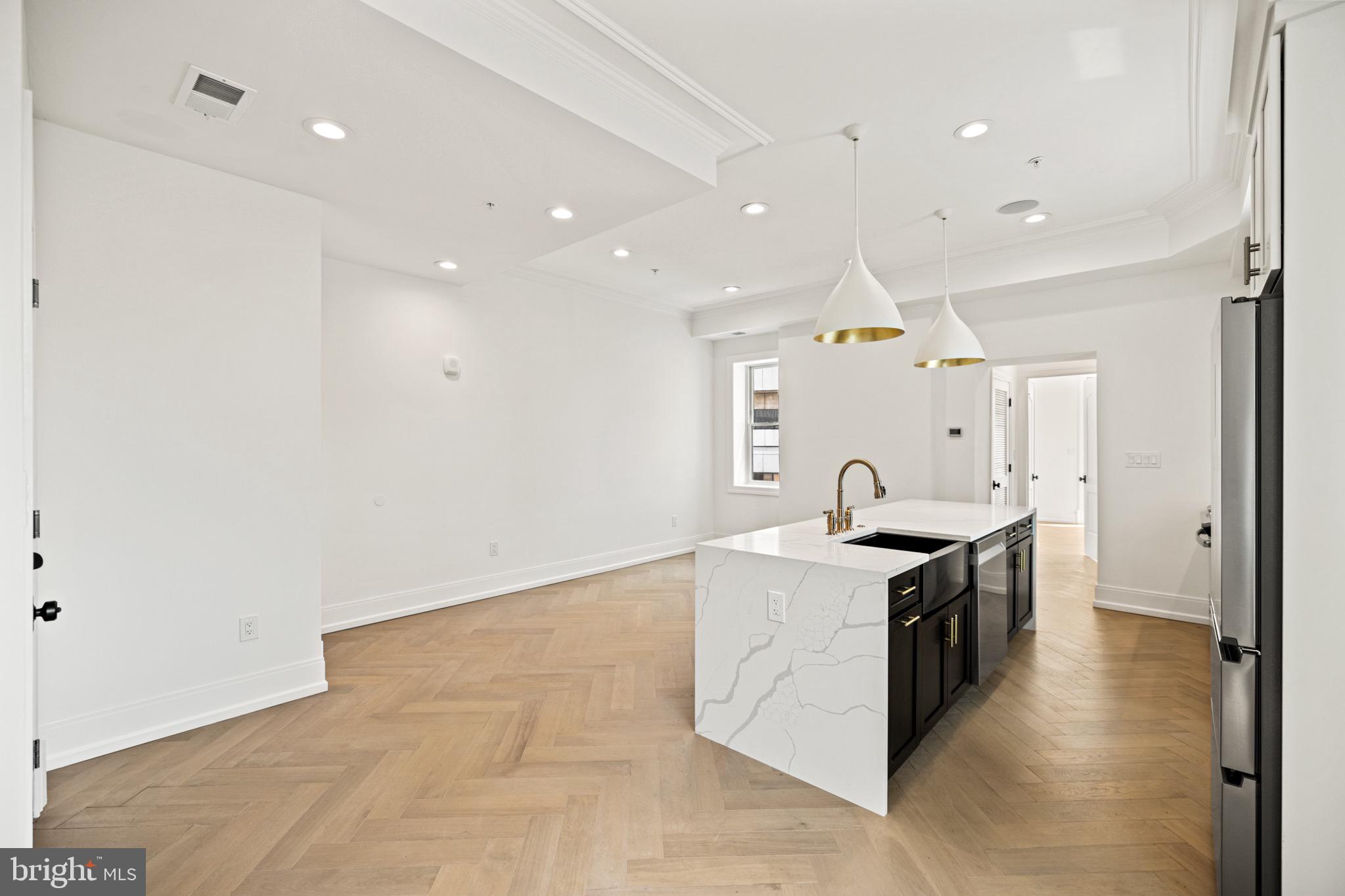 1709 21st Street Northwest, Unit 42 Washington, DC 20009 - Photo 5 of 21 a large kitchen with stainless steel appliances a large counter top a sink a stove and a refrigerator
