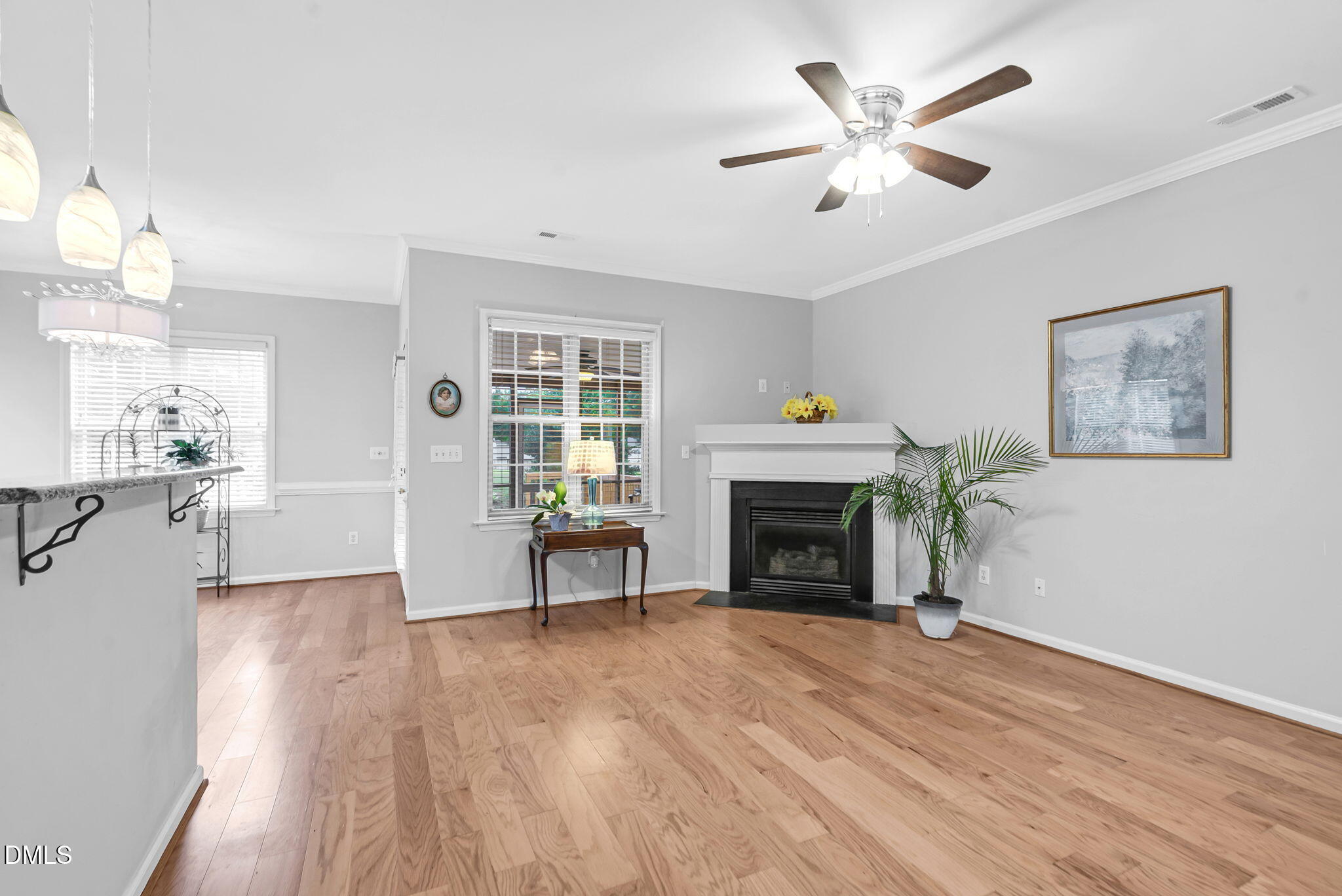 5512 Grand Traverse Drive Raleigh, NC 27604 - Photo 11 of 62 a view of a livingroom with a fireplace a ceiling fan and wooden floor