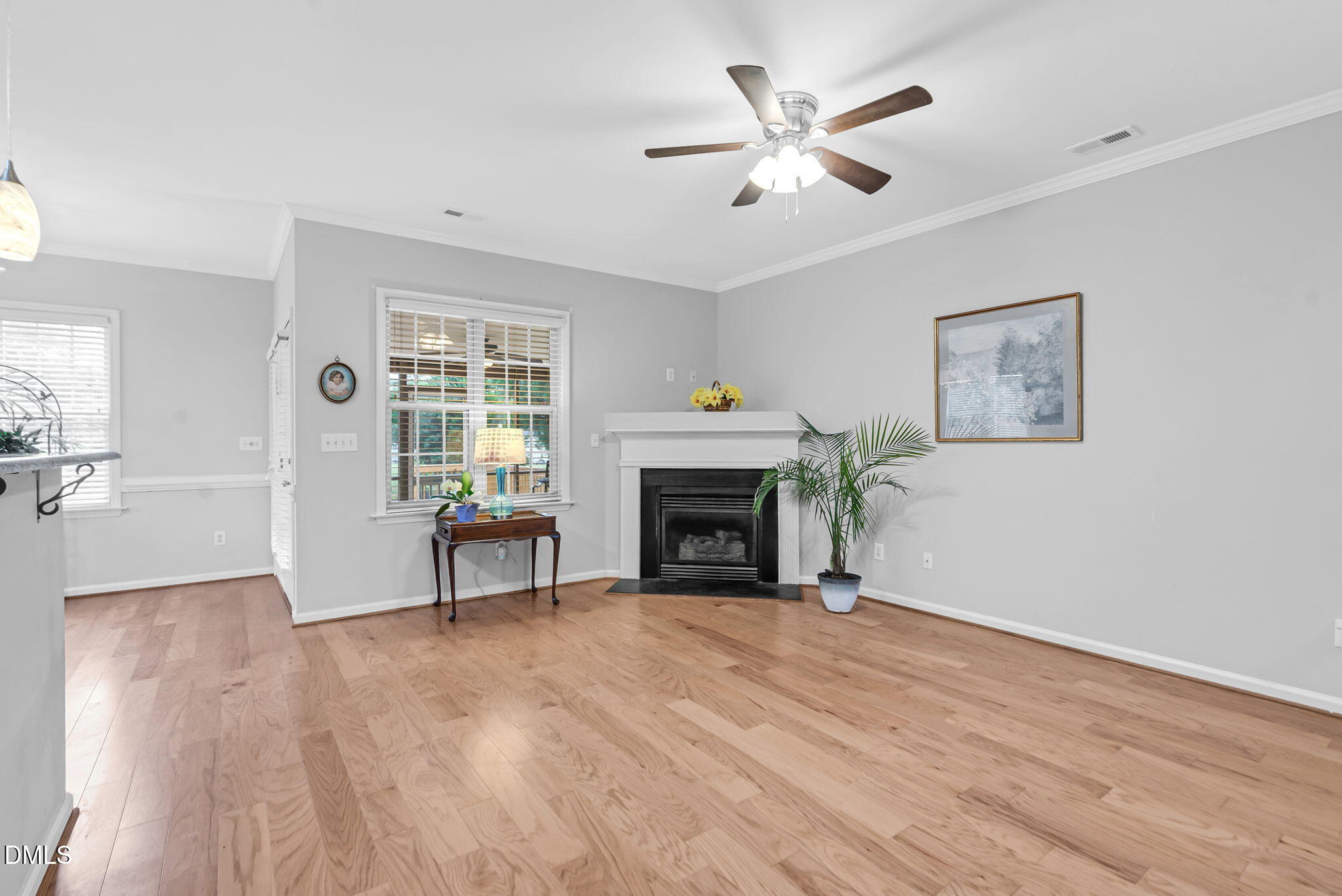5512 Grand Traverse Drive Raleigh, NC 27604 - Photo 7 of 62 a view of a livingroom with a fireplace a ceiling fan and wooden floor