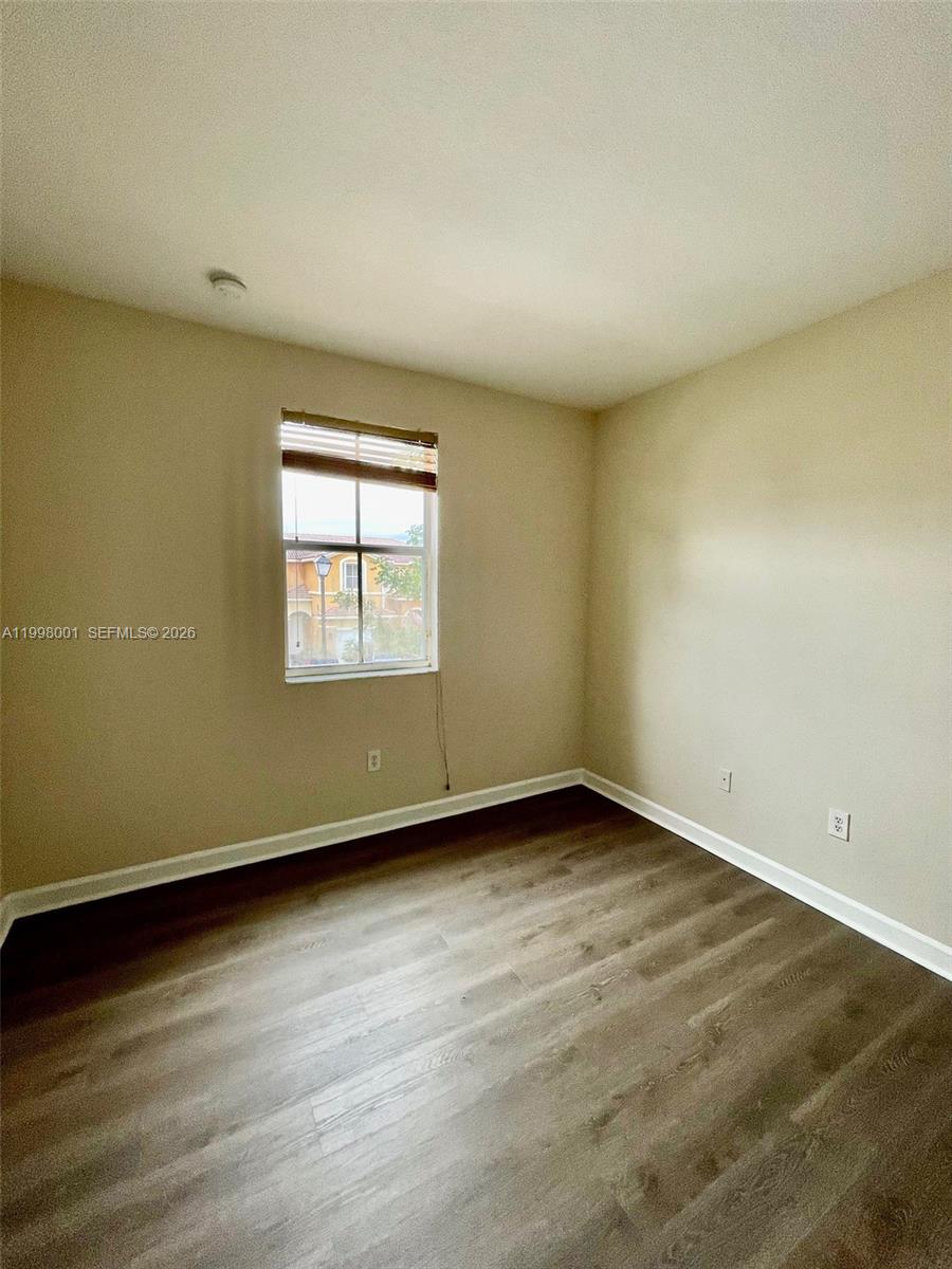 24651 Southwest 110th Avenue Homestead, FL 33032 - Photo 16 of 26 an empty room with wooden floor and windows