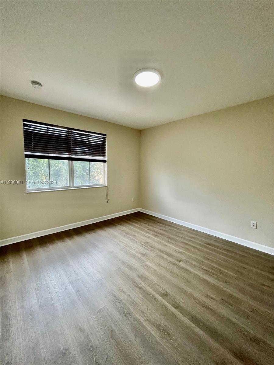 24651 Southwest 110th Avenue Homestead, FL 33032 - Photo 20 of 26 a view of an empty room with wooden floor and a window