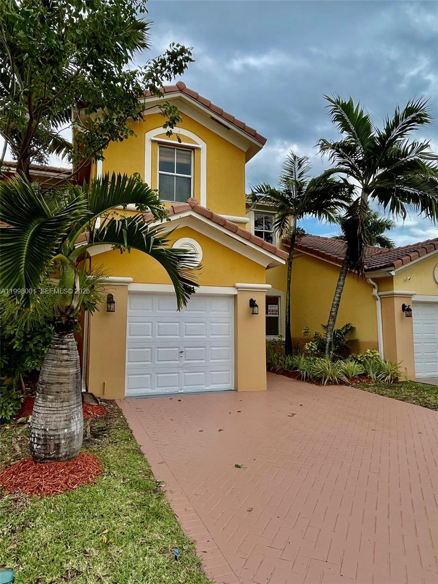24651 Southwest 110th Avenue Homestead, FL 33032 - Photo 2 of 26 a front view of a house with a yard and garage