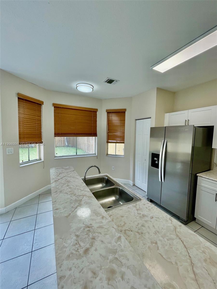 24651 Southwest 110th Avenue Homestead, FL 33032 - Photo 8 of 26 a kitchen with granite countertop a refrigerator and a sink
