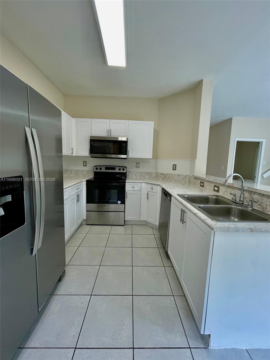 24651 Southwest 110th Avenue Homestead, FL 33032 - Photo 10 of 26 a kitchen with stainless steel appliances granite countertop a refrigerator and a stove top oven