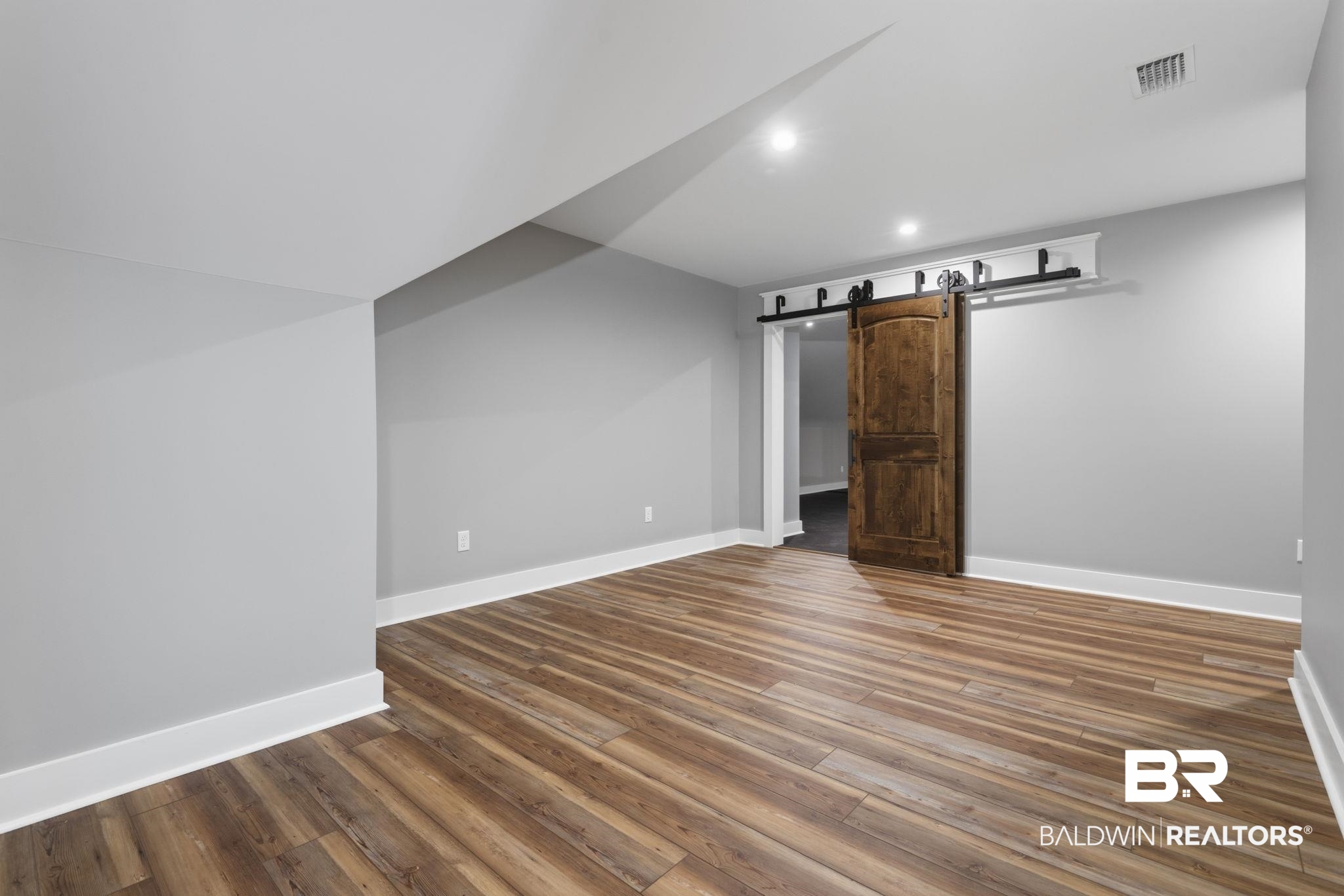 9501 Ben Hamilton Road Theodore, AL 36582 - Photo 51 of 69 Basement featuring a barn door, dark wood-style floors, and recessed lighting