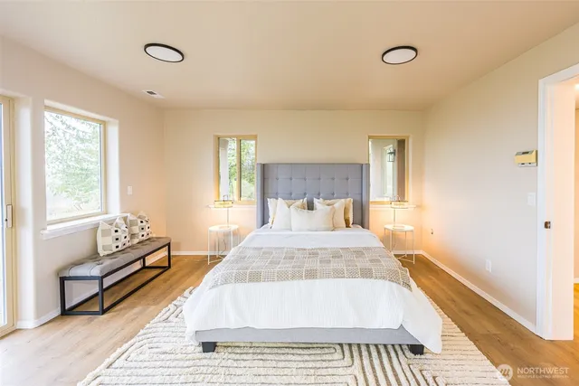 a spacious bedroom with a bed and wooden floor