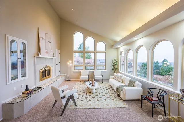 a living room with furniture fireplace and a large window