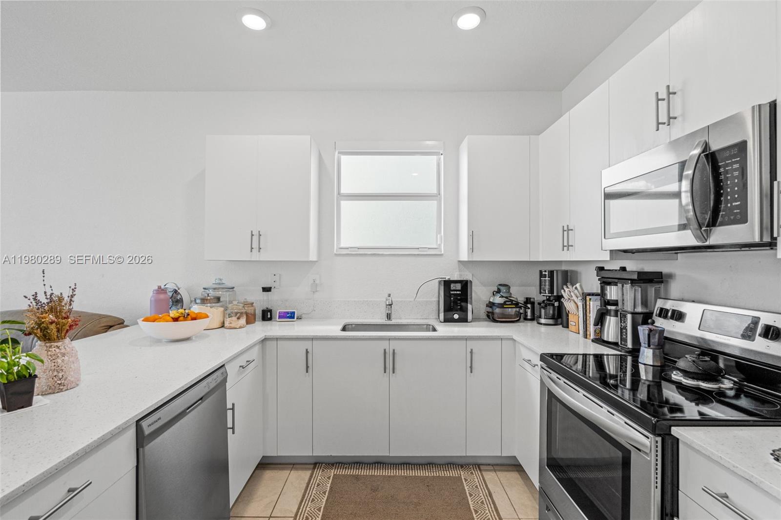 12731 Southwest 213th Street Miami, FL 33177 - Photo 11 of 41 a view of a kitchen with a sink stove top oven and cabinets