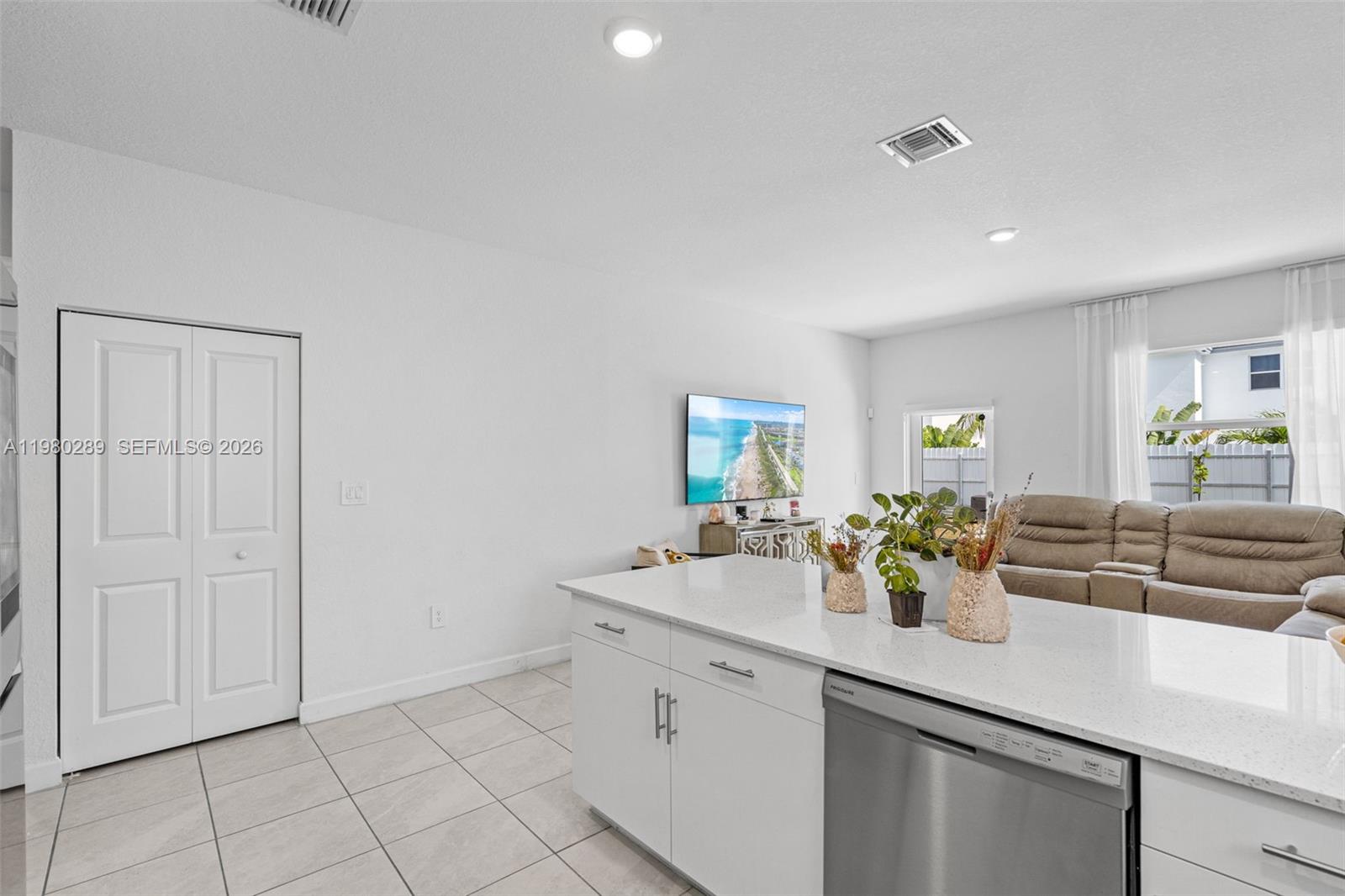 12731 Southwest 213th Street Miami, FL 33177 - Photo 13 of 41 a kitchen with a sink dishwasher and white cabinets with wooden floor