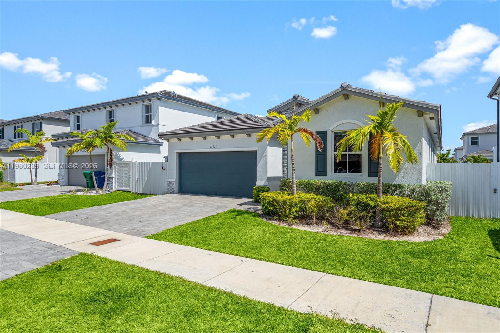 12731 Southwest 213th Street Miami, FL 33177 - Photo 2 of 41 a front view of a house with a garden and plants