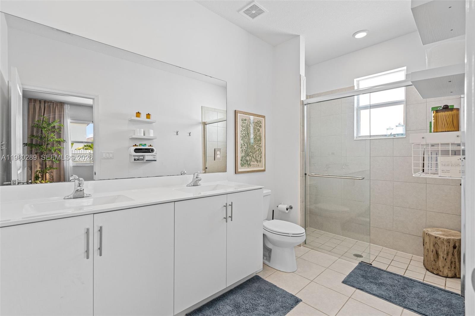 12731 Southwest 213th Street Miami, FL 33177 - Photo 23 of 41 a bathroom with a double vanity sink toilet and a mirror