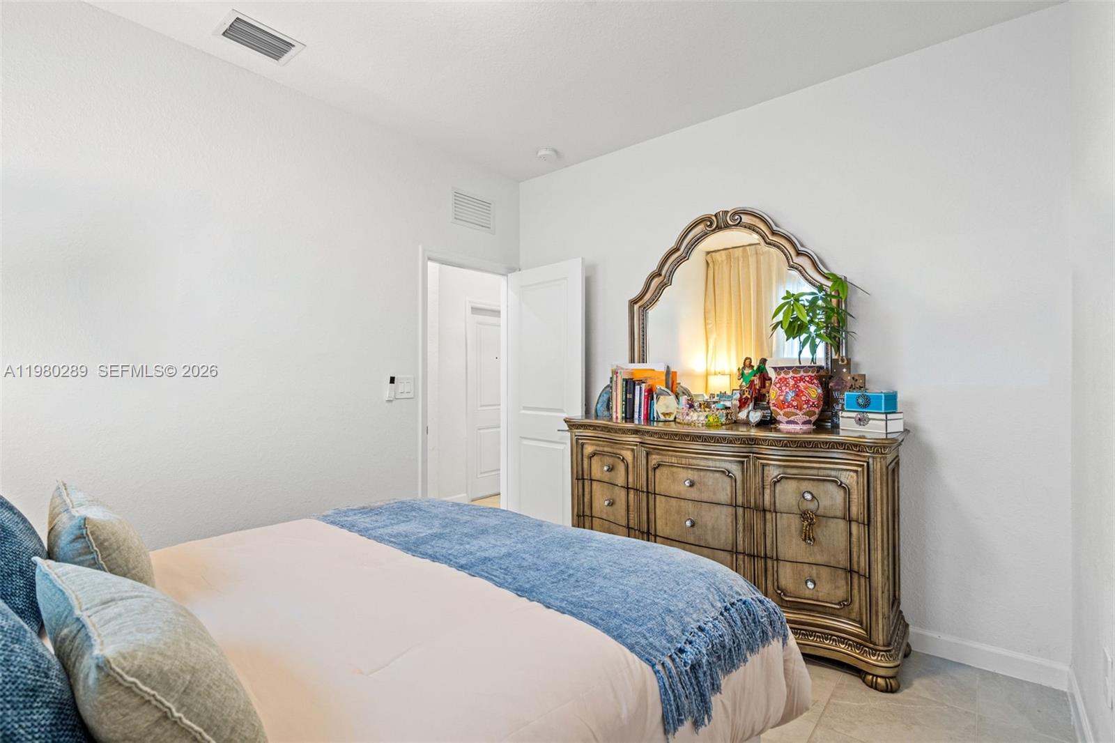 12731 Southwest 213th Street Miami, FL 33177 - Photo 25 of 41 a bedroom with a bed and a mirror on dresser