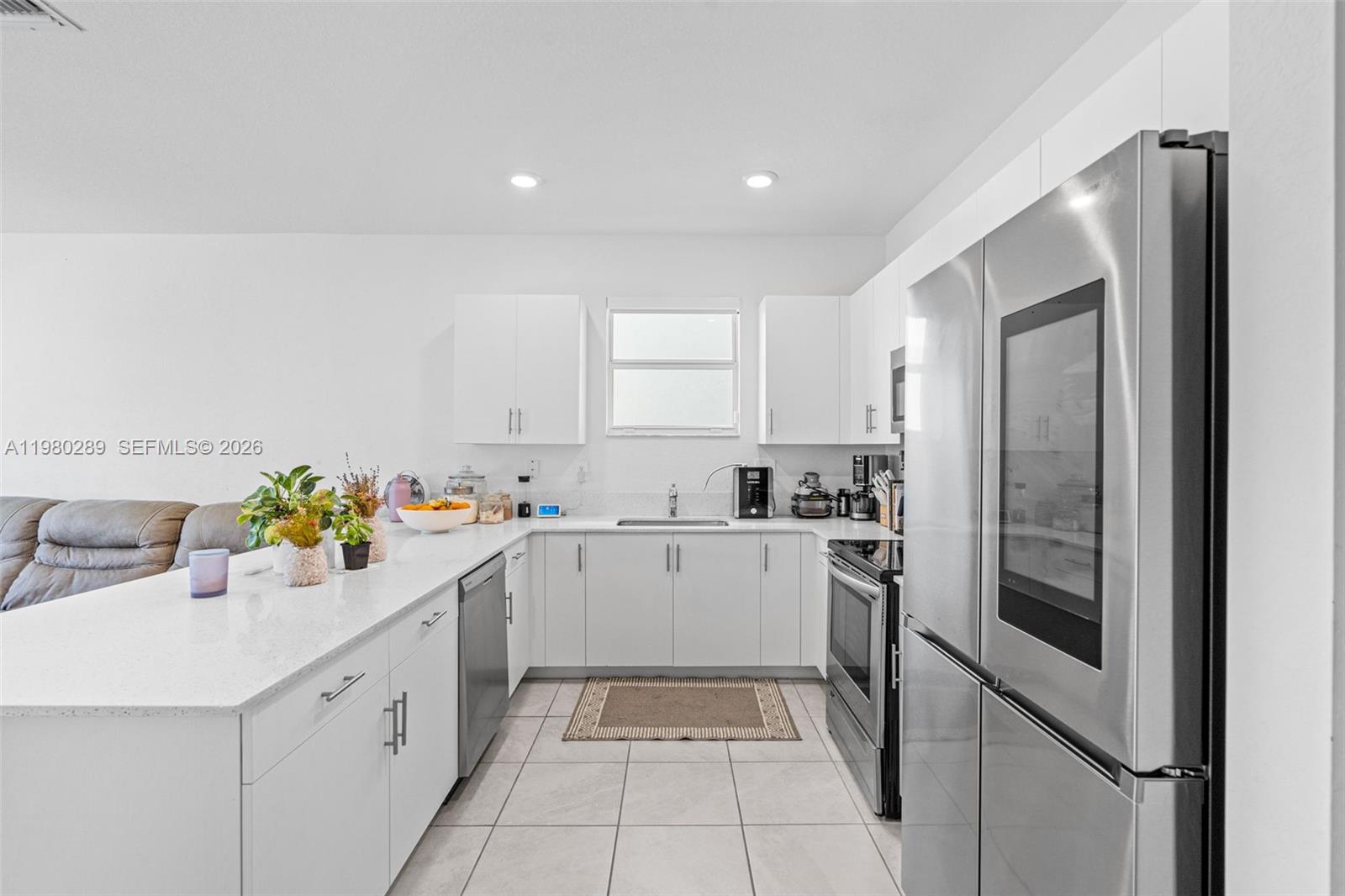12731 Southwest 213th Street Miami, FL 33177 - Photo 10 of 41 a kitchen with a sink window and cabinets