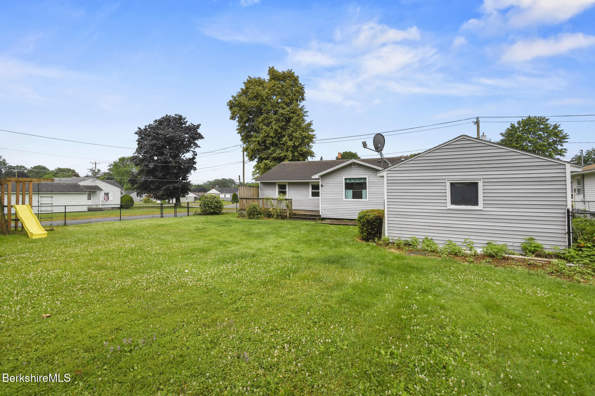 36 Dalton Division Road Dalton, MA 01226 - Photo 6 of 35 a white house with a small yard and trees all around
