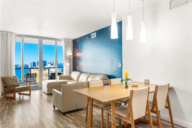 a living room with couches a fireplace and four dining tables with wooden floor