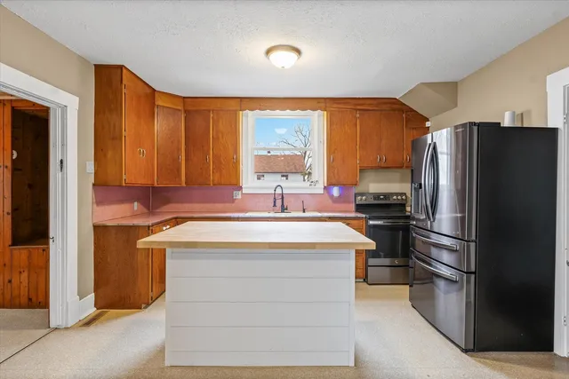a kitchen with stainless steel appliances a refrigerator sink and stove