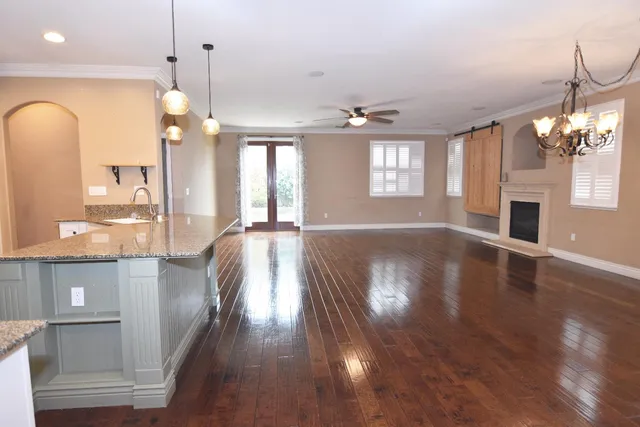 a view of a living room a chandelier and wooden floor