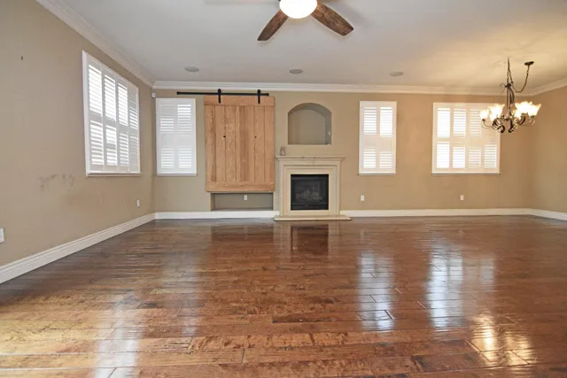 a view of empty room with fireplace and wooden floor