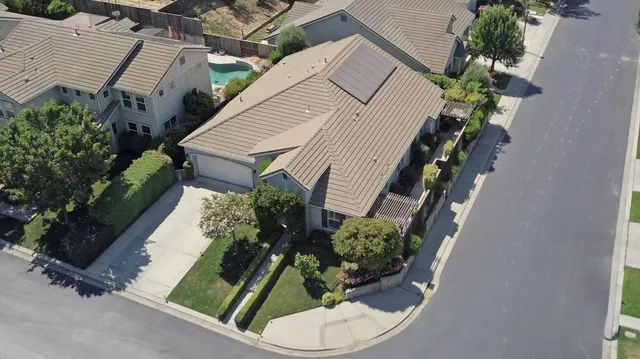 an aerial view of a house with a yard and potted plants