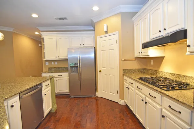 a kitchen with granite countertop a sink stove and refrigerator