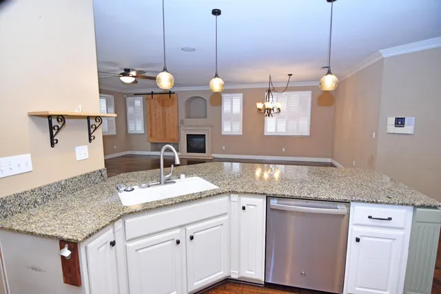 a kitchen with granite countertop cabinets and a chandelier