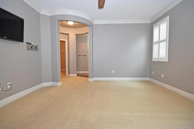 an empty room with windows and fireplace