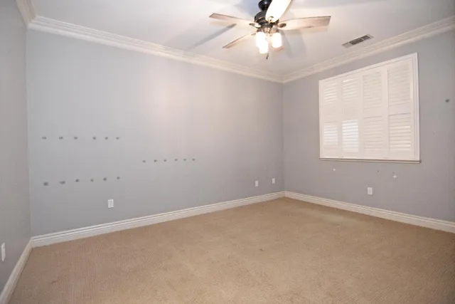 an empty room with a window and a fan