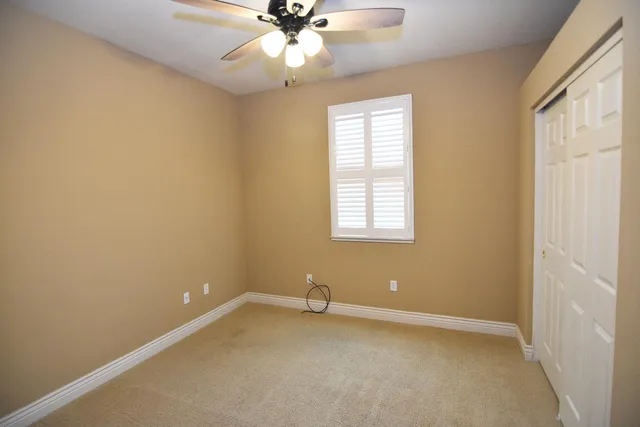 an empty room with a window and a fan