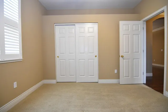 an empty room with windows and closet