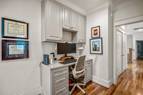 a view of a workspace with furniture and a window