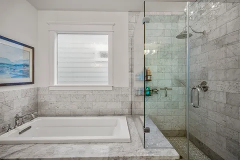a white bath tub sitting next to a shower