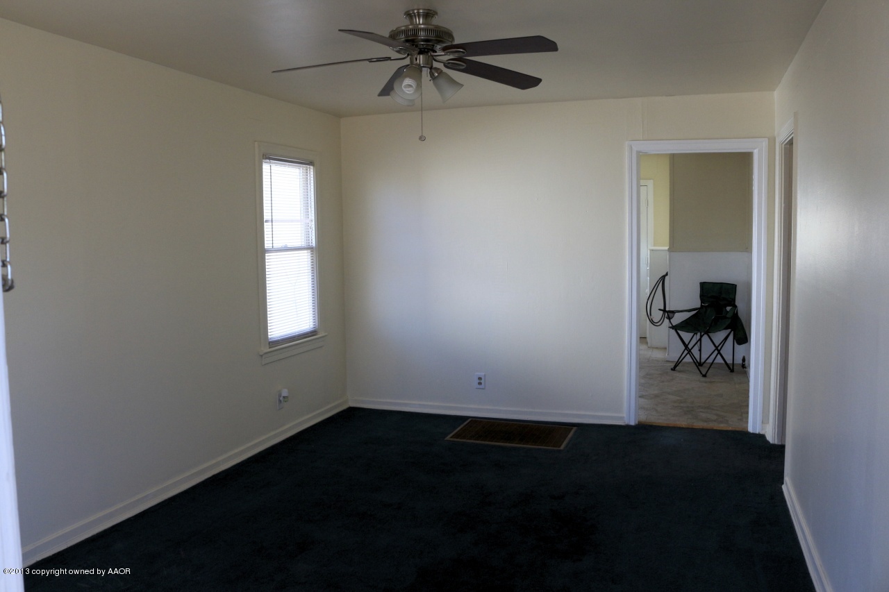 4115 South Ong Street Amarillo, TX 79110 - Photo 3 of 15 wooden floor in an empty room with a window