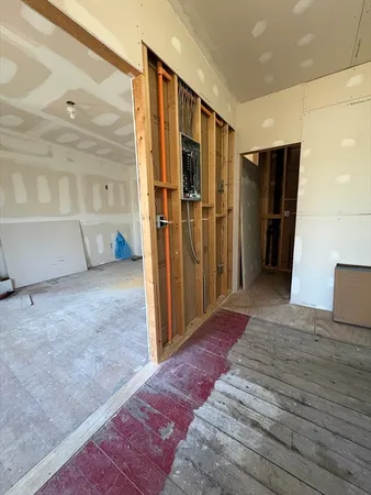 a view of hallway with wooden floor and cabinet
