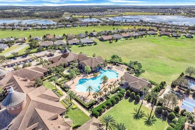an aerial view of ocean and residential houses with outdoor space