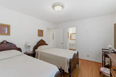 a bedroom with two beds and a desk