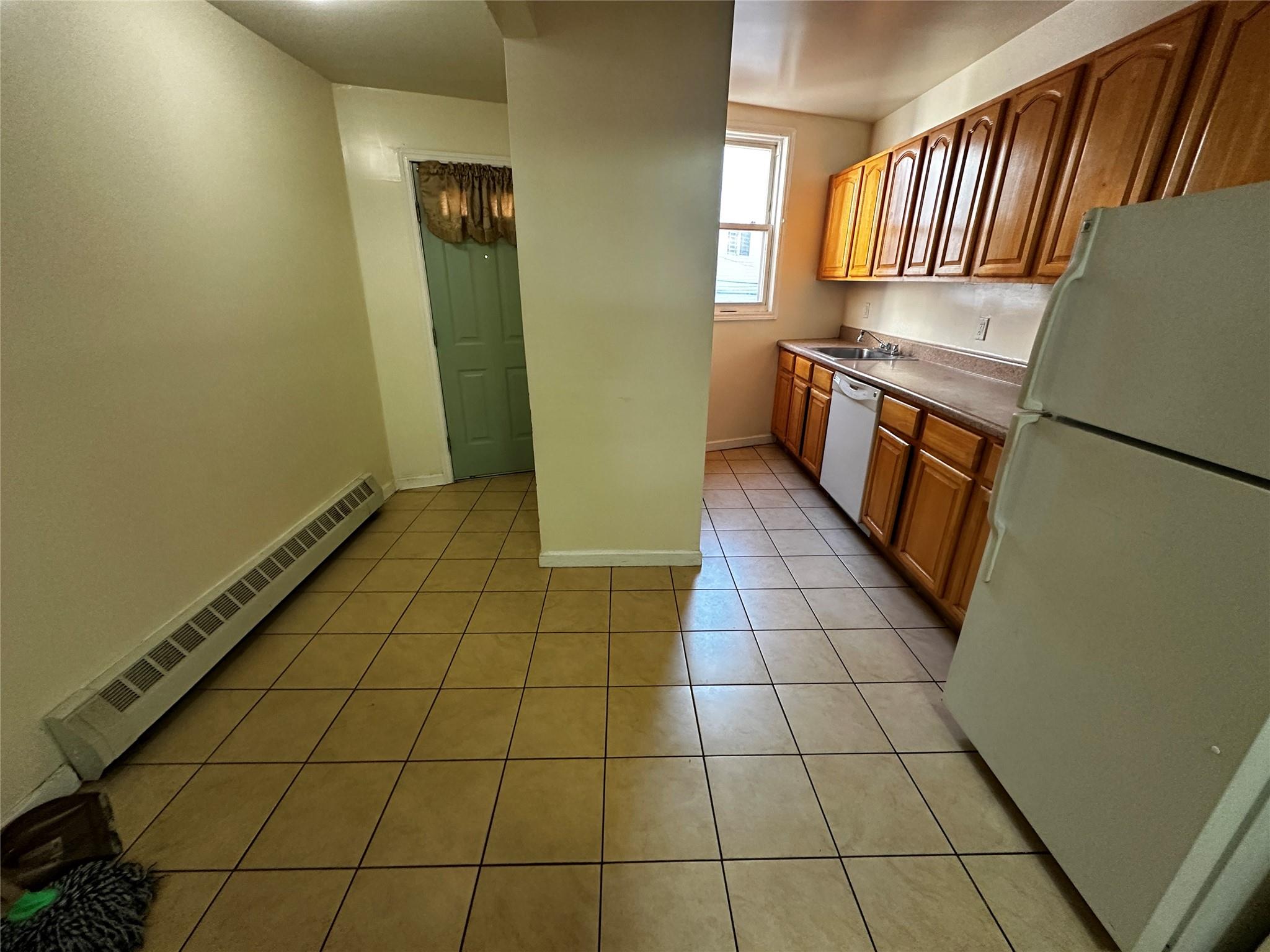 1316 Myrtle Avenue Brooklyn, NY 11221 - Photo 26 of 32 2ND FLRKitchen featuring sink, white appliances, baseboard heating, and light tile patterned floors