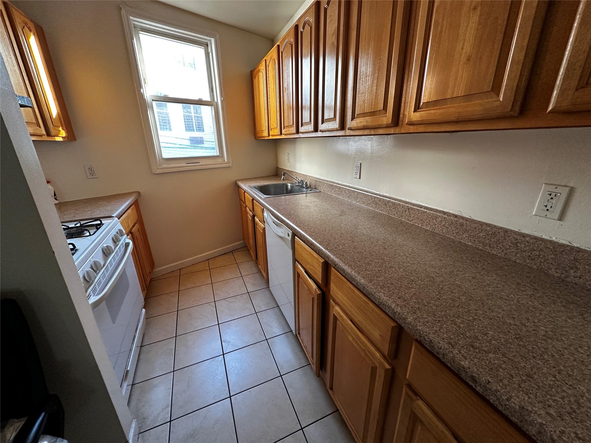 1316 Myrtle Avenue Brooklyn, NY 11221 - Photo 27 of 32 2ND FLRKitchen with sink, light tile patterned floors, and white appliances