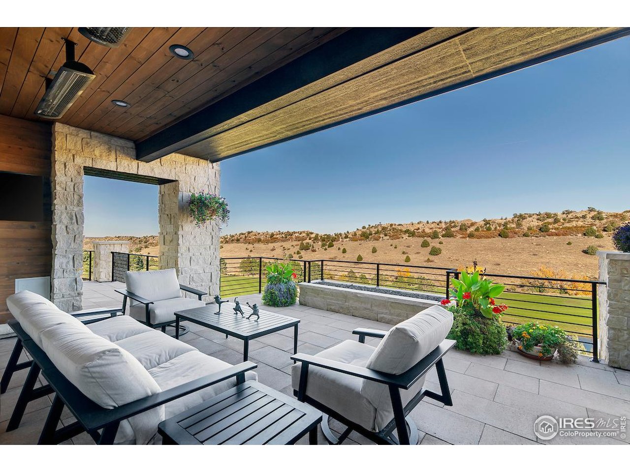 7572 Raphael Lane Littleton, CO 80125 - Photo 16 of 50 Tongue-and-groove ceilings, flagstone-accented walls, a sleek modern firepit, and built-in grill and smoker define this as an entertainer's haven where sunrise coffees and twilight gatherings share the same breathtaking backdrop.