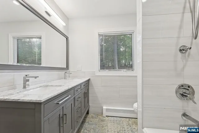 a bathroom with a tub sink and mirror