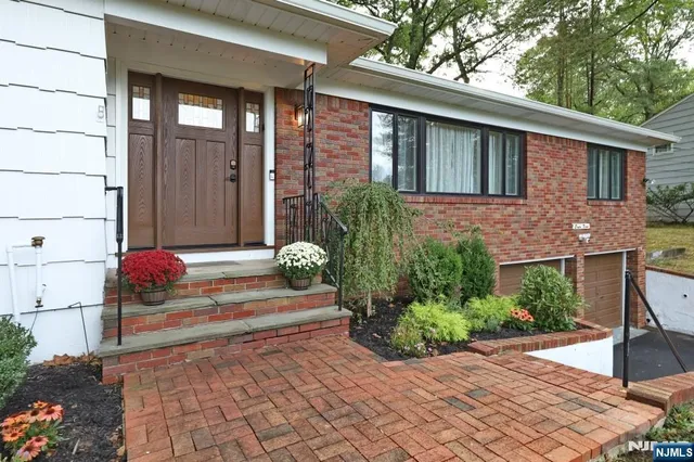 a front view of a house with a large window and potted plants