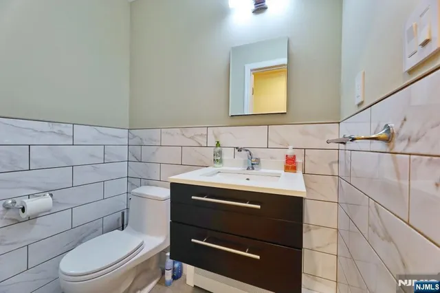 a view of a hallway with wooden floor and a bathroom