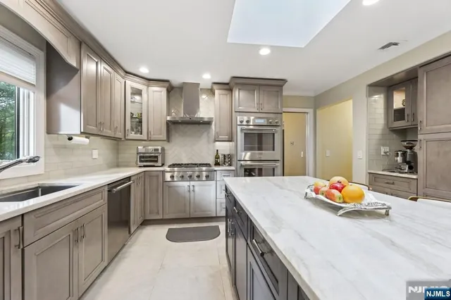 a kitchen with stainless steel appliances granite countertop a sink and a refrigerator