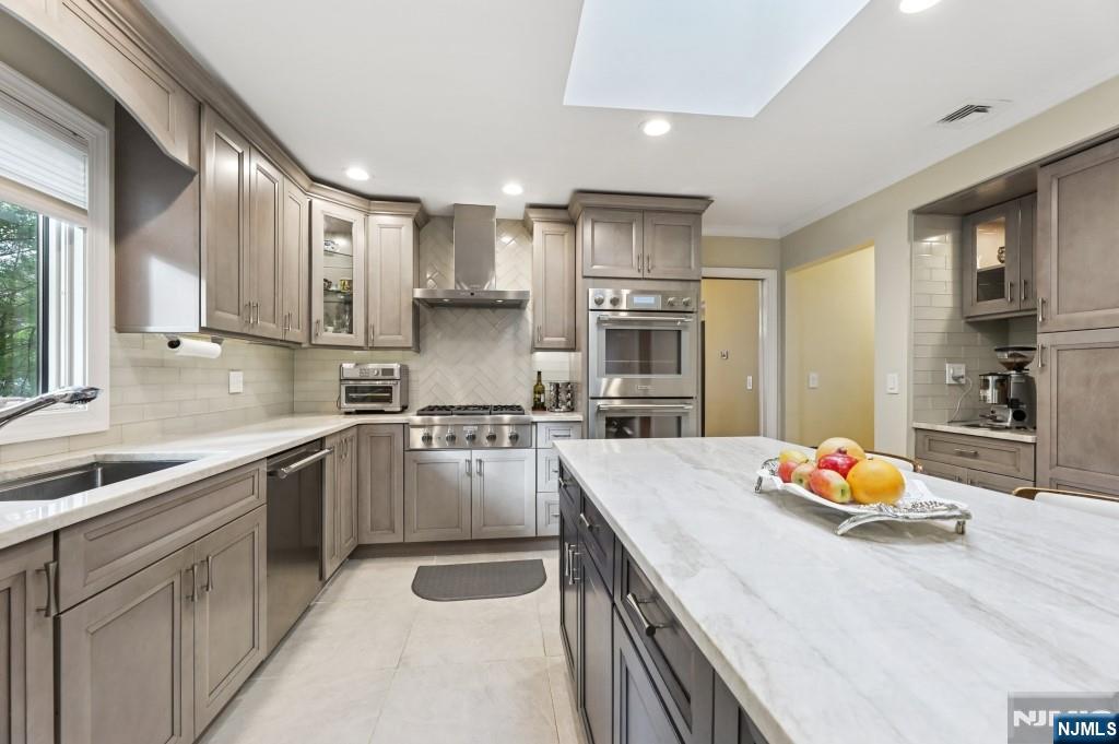 83 Hampshire Road Washington Township, NJ 07676 - Photo 29 of 40 a kitchen with stainless steel appliances kitchen island granite countertop a sink stove and refrigerator