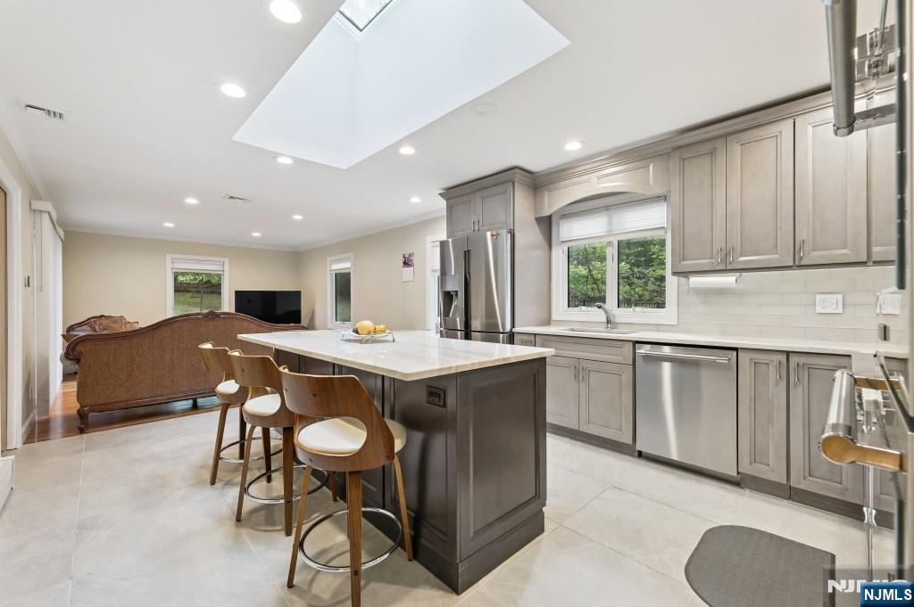 83 Hampshire Road Washington Township, NJ 07676 - Photo 32 of 40 a kitchen with a table chairs sink and cabinets