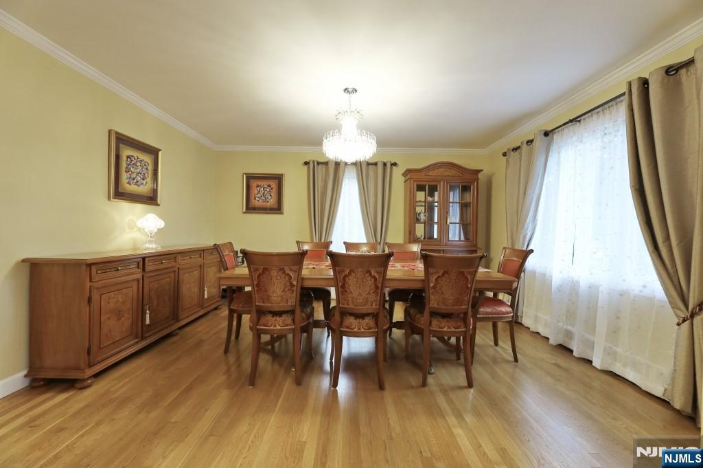 83 Hampshire Road Washington Township, NJ 07676 - Photo 33 of 40 a dining room with wooden floor a chandelier a wooden table and chairs