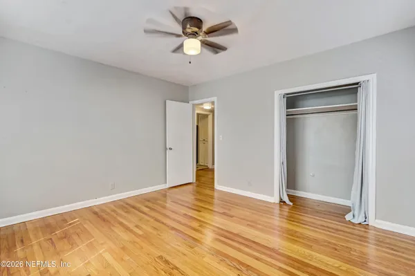 a view of empty room with wooden floor