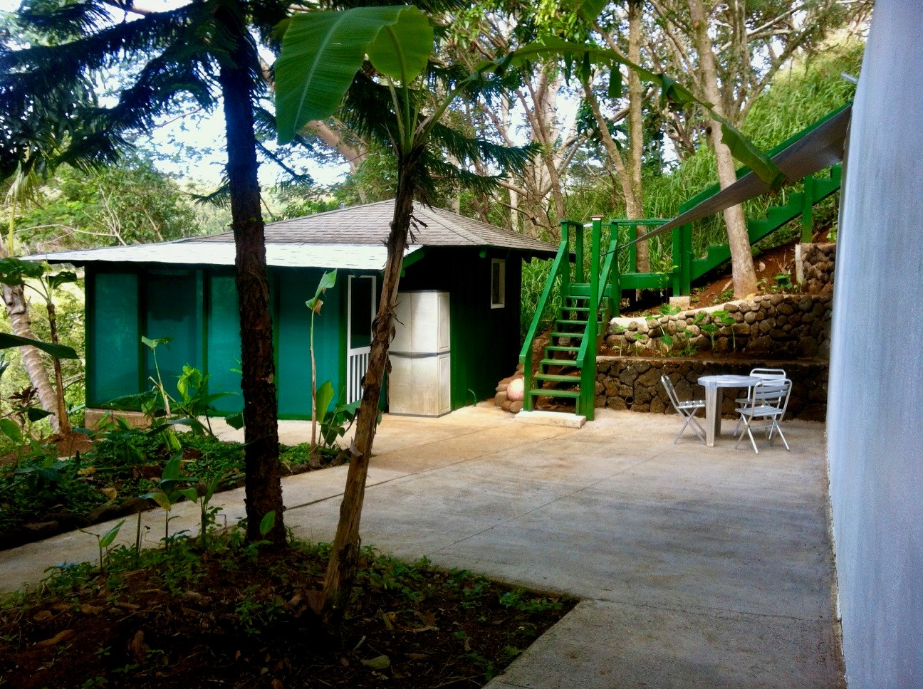 3198 Wawae Road Kalaheo, HI 96741 - Photo 21 of 30 a backyard of a house with table and chairs potted plants and large tree