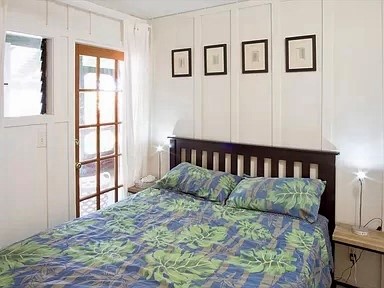 3198 Wawae Road Kalaheo, HI 96741 - Photo 7 of 30 a bed sitting in a bedroom next to a window